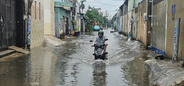 TP.HCM: Ngập sâu, người đi đường 'chôn chân' chờ nước rút - Ảnh 3.