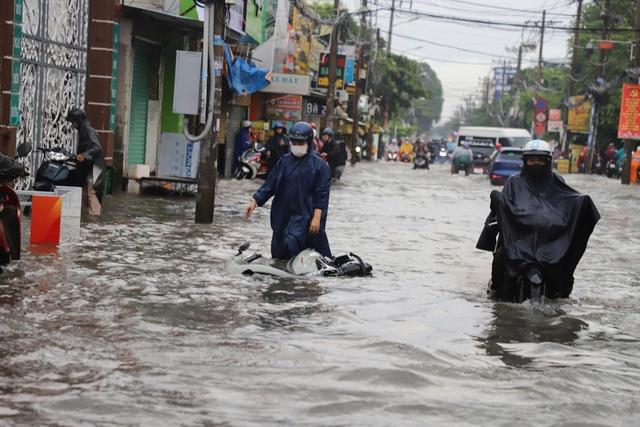 TP.HCM: Ngập sâu, người đi đường 'chôn chân' chờ nước rút - Ảnh 1.