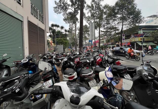 TP . HCM Tái diễn tình trạng chiếm dụng vỉa hè và thu phí giữ xe cao - Ảnh 8.