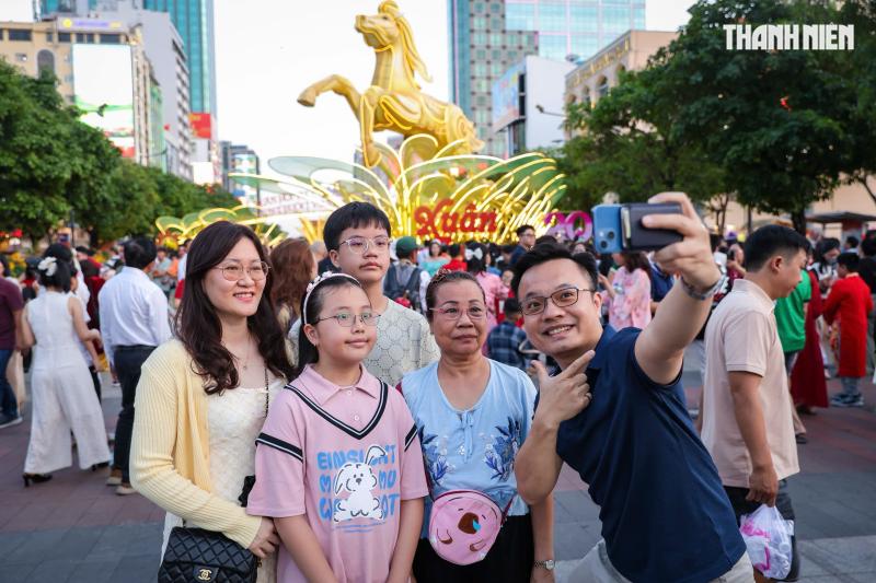 Giao thừa đêm 29 tết: Đông nghẹt người dân TP.HCM, du khách đến đường hoa Nguyễn Huệ - Ảnh 1.