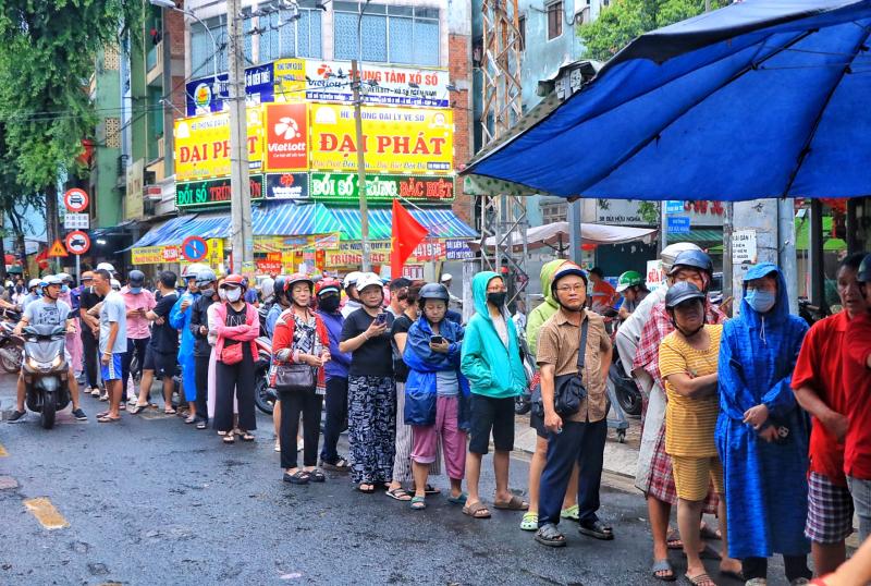 Sáng nay hàng dài người dân TP.HCM đội mưa mua vịt quay, heo quay ngày Thần tài - Ảnh 1.