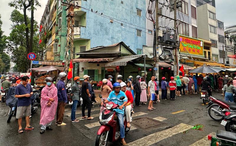 Sáng nay hàng dài người dân TP.HCM đội mưa mua vịt quay, heo quay ngày Thần tài - Ảnh 7.