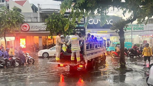 CSGT dùng xe đặc chủng chở người dân vượt đường ngập sâu giữa mưa lớn ở TP.HCM - Ảnh 2.