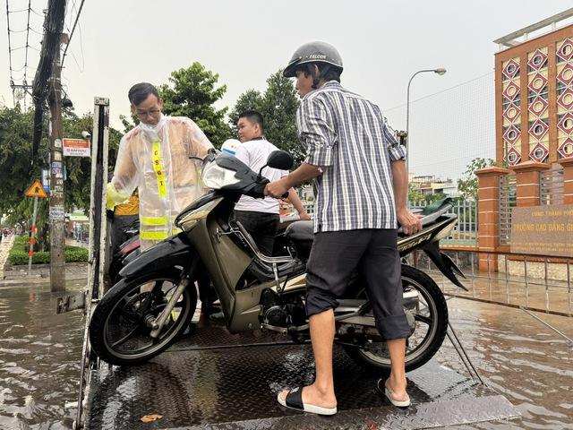 CSGT dùng xe đặc chủng chở người dân vượt đường ngập sâu giữa mưa lớn ở TP.HCM - Ảnh 3.